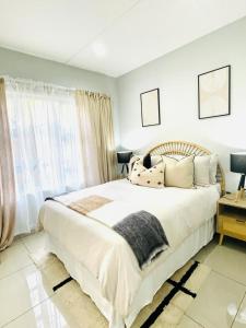 乌姆塔塔Trendy, Comfortable 1 bedroom Apartments in Mthatha的卧室设有一张白色大床和一扇窗户。