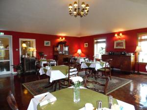 凯恩莱安嘉乐威兰斯酒店的一间设有桌椅的餐厅,位于带红色墙壁的房间