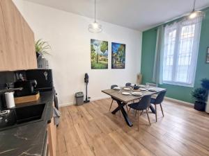 尼姆Nimes: Appartement l'Auguste Centre-Ville.的厨房以及带桌椅的用餐室。