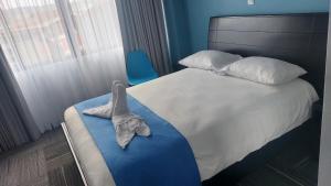 圣伊西德罗Lucky`s Hotel & Casino的一间卧室配有一张床,床上有毛巾
