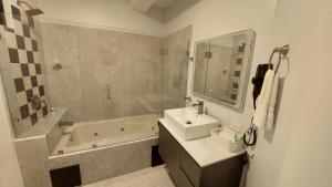 圣伊西德罗Lucky`s Hotel & Casino的浴室配有盥洗盆、浴缸和盥洗盆
