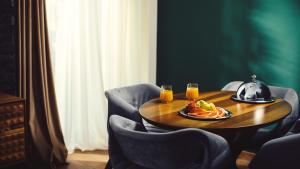 TsalkaKass Diamond Resort的一张桌子,上面放着一盘食物和两杯橙汁