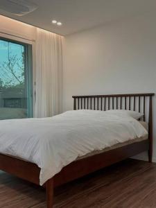 济州市Jejudo Luxury Private House的卧室内的一张大床,设有窗户