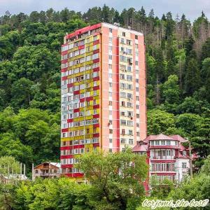 博尔若米Apartament Luka的山前高高的建筑,有五颜六色的窗户