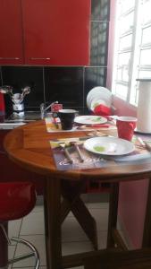 黑角ptit coin hibiscus的厨房里一张木桌,配有盘子和餐具