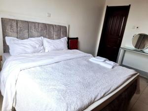 阿西里弗Jkia 3 bedroom greatwall gardens phase 4的卧室配有一张白色大床和木制床头板