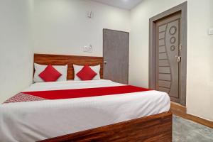海得拉巴OYO Flagship Hotel Lavish Stay的一间卧室配有一张带红色枕头的大床