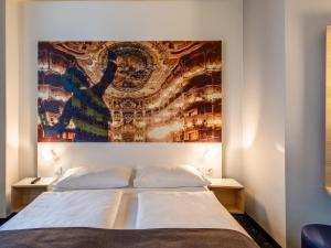 拜罗伊特B&B Hotel Bayreuth的卧室配有一张大床上方的大画