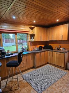 ĶegumsHoliday house/Brīvdienu māja in Kegums的厨房配有木制橱柜、椅子和水槽