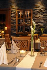 道恩Landhotel Lodge by Landhotel Krolik的一张带蜡烛的桌子和一个带花的花瓶
