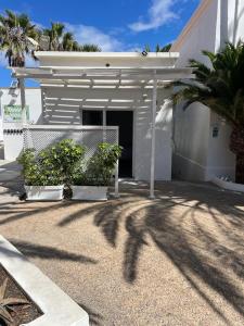 科拉雷侯Apartamentos Punta Elena Beach的一座白色的房子,有门和一些植物