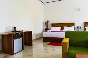 蒂瑟默哈拉默Yala Hotel Elephant Eye的酒店客房,设有一张床铺和一张绿色沙发