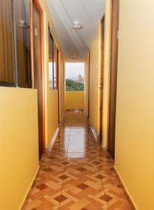利马Female Accommodation Experience in front of Lima Airport的走廊上设有黄色墙壁和木地板的办公室