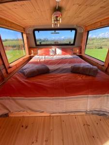 IrvinestownSleeps 6/bus/hottub/sauna/Pets/Hens的一张位于带2扇窗户的客房中间的床