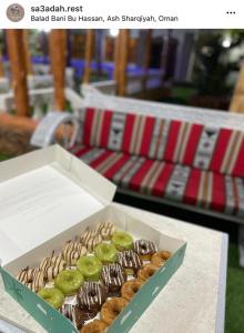 Jalan Bani Buhassanأستراحة السعادة的桌子上一盒甜甜圈
