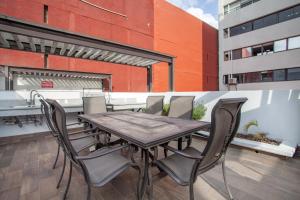 墨西哥城Corazón de Condesa 3 departamentos - 200Mbps WiFi, Roof, Gym的阳台上的木桌和椅子