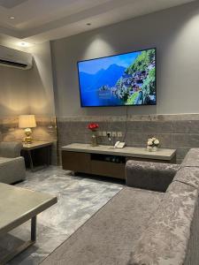 泰布克درة اجنادين للشقق المخدومة的客厅配有沙发和墙上的电视