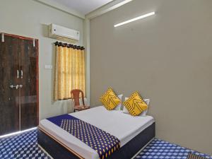 SakardarāOYO Hotel G.K Lodging and Guest House的一间卧室配有一张黄色和蓝色床单的床