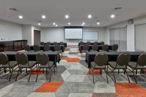 阿林顿Comfort Suites Arlington - Entertainment District的一间会议室,配有桌椅和屏幕