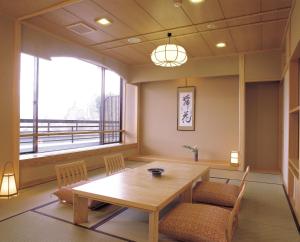 富士河口湖丸荣日式旅馆的客房设有桌椅和大窗户。
