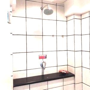 波德申Le Seaview PortDickson的带淋浴的浴室和白色瓷砖墙壁
