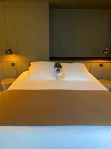 圣马洛Hôtel L'Adresse的一间卧室配有一张带两个白色枕头的大床