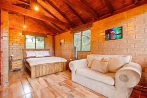 NemocónCabaña Tipo Glamping Savieza Life Experience的一间卧室配有一张床和一个沙发