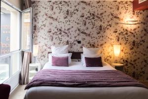 圣马洛Hôtel L'Adresse的卧室配有一张墙上鲜花的大床