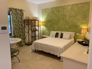 GussagoVilla Marta bed and breakfast的卧室配有白色的床和绿色的墙壁