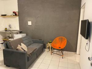 大坎皮纳Flat próximo ao Centro de CG com Wifi rápida的带沙发和橙色椅子的客厅