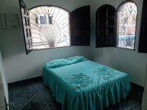 马瑙斯Casa grande em área central, bem iluminada e vent.的配有2扇窗户的客房内的1张床