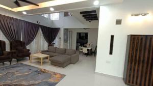 Kampong ChinchangMysha KLIA F1 Homestay with pool,WiFi , Netflix的客厅配有沙发和桌子