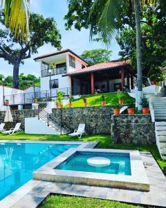 TamaniqueHabitaciones Casa Cuscatlan的一座带游泳池和房子的别墅