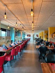 勒兹比斯道普希里普酒店的用餐室配有桌子和红色椅子