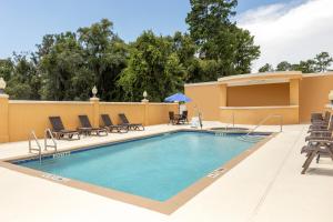 湖城莱克城舒适套房酒店的一个带椅子的庭院内的游泳池