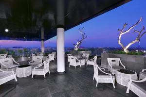 日惹Hotel Neo Malioboro by ASTON的一间设有白色椅子的餐厅,享有城市美景