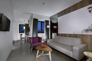 日惹Hotel Neo Malioboro by ASTON的客厅配有沙发和桌子