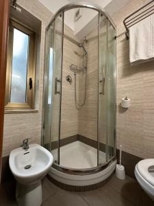 米兰尼萨酒店的带淋浴、卫生间和盥洗盆的浴室