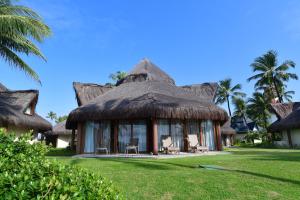 嘎林海斯港Summerville Resort - All Inclusive的拥有茅草屋顶、椅子和棕榈树的度假村