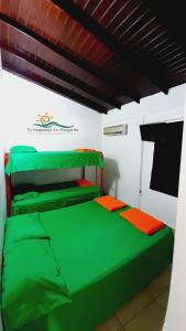 ParaguachiCasa Vacacional Lomas de Guayamury的一间位于客房内的带绿床的卧室
