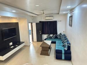 达曼Chirag Banglow 2BHK的带沙发和平面电视的客厅