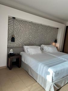 那不勒斯巴巴托酒店的卧室配有一张白色大床和一张边桌