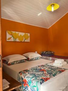 伊利亚贝拉Suites Helena的橙色墙壁客房的两张床