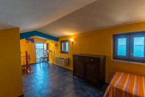 切法卢MiraMare Residence Cefalú的卧室拥有黄色的墙壁,设有一张床和窗户。