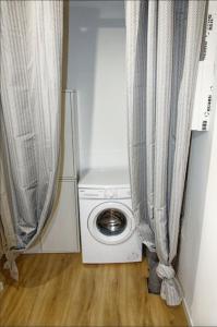 梅克西米约Le St Apollinaire n°2-Ma Cabotte的配有窗帘的小房间内的洗衣机