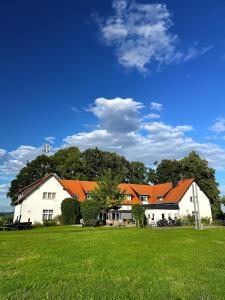 HabrachćicyHainberg Hotel的绿色田野上带橙色屋顶的大型白色房屋