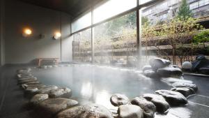 雫石町Oshuku Onsen Choeikan - Vacation STAY 55578v的一间有岩石的水池的房间