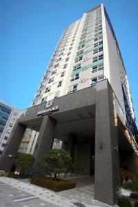 首尔江南城市广场酒店的一座高大的建筑,前面有标志