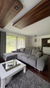 索利纳Dom - Apartamenty Prestige - opcja jacuzzi i sauna的客厅配有大沙发和桌子