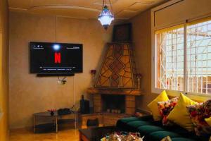 乌季达Magnifique Villa tout confort proche du Centre-ville的客厅配有电视、沙发和壁炉